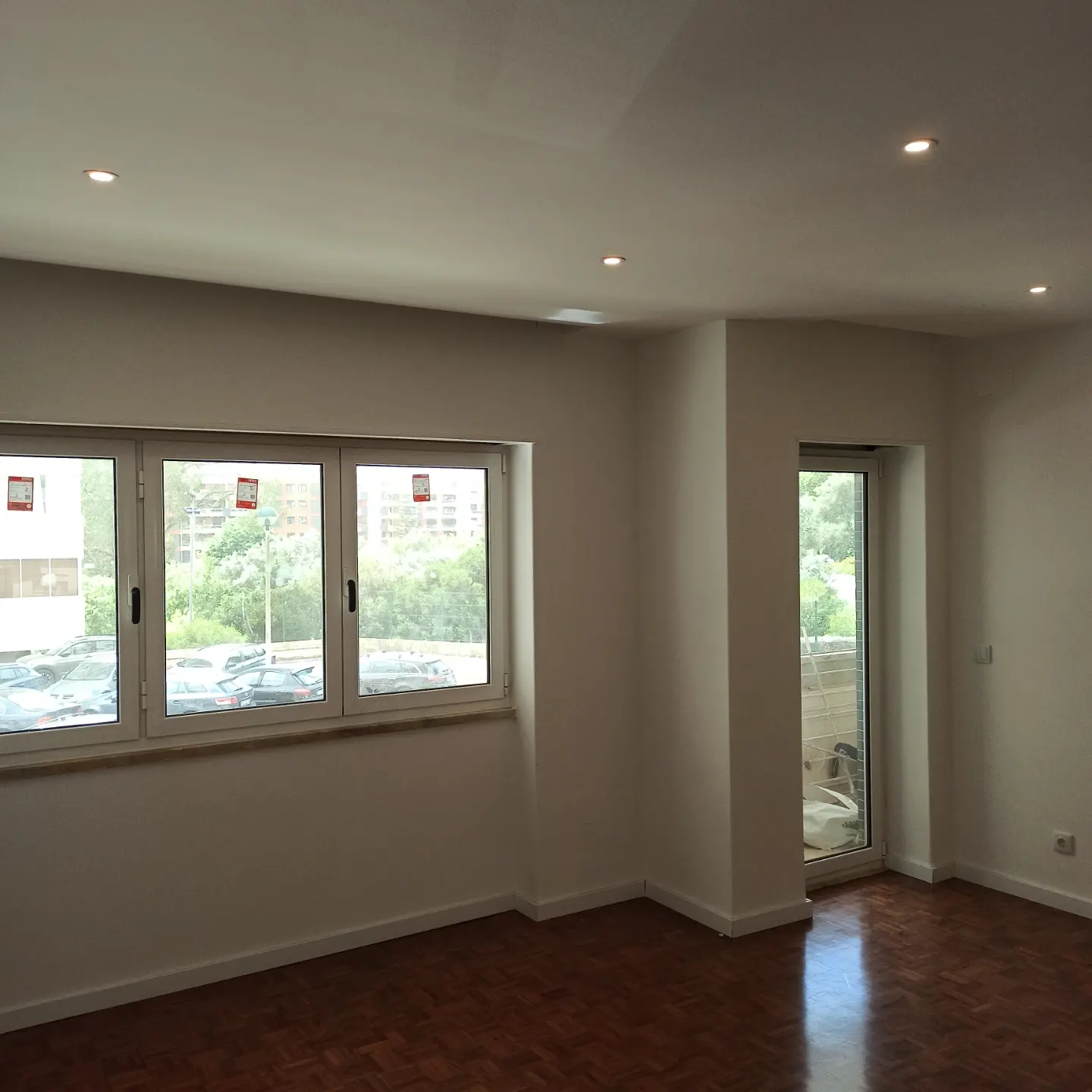 Sala concluída de uma reabilitação de apartamento em Lisboa, com pintura clara e pavimento de madeira